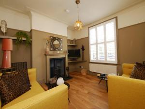 a living room with yellow furniture and a fireplace at Bar Wall Cottage-City Wall Views-sleeps 5 in York