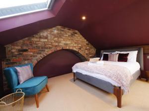 a bedroom with a bed and a chair at Bar Wall Cottage-City Wall Views-sleeps 5 in York
