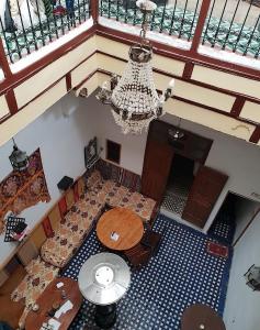 een kamer met tafels en een kroonluchter bij Moroccan Dream Hostel in Fès