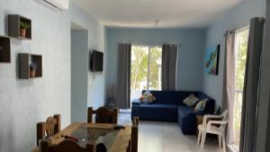 sala de estar con sofá azul y mesa en Brand new apartment, charming and family-friendly en Playa del Carmen