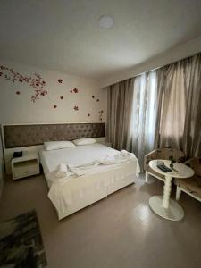 - une chambre avec un lit blanc et une table dans l'établissement Select City Center Hotel, à Tirana