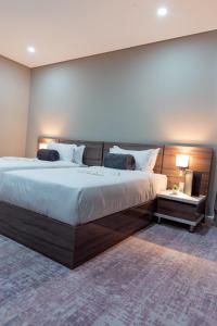 een slaapkamer met een groot bed met een houten hoofdeinde bij Polana Plaza Hotel in Maputo