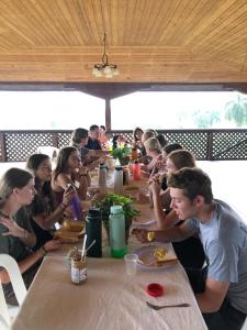a group of people sitting at a table eating food at Complejo Ecoturistico Rancho Cielo in Licey al Medio