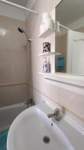 y baño con lavabo blanco y espejo. en alquilaencanarias El Medano beach 1, en El Médano