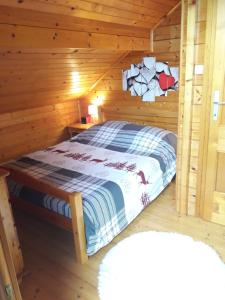 een slaapkamer met een bed in een houten hut bij chalet La Vallée in La Bresse