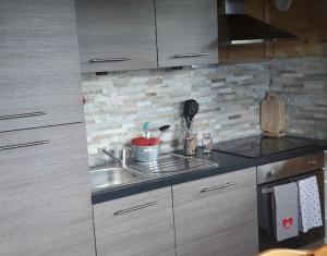 a kitchen with a sink and a microwave at chalet La Vallée in La Bresse
