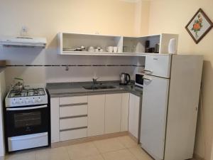 eine Küche mit einem weißen Kühlschrank und einer Spüle in der Unterkunft El Oasis in Saladillo