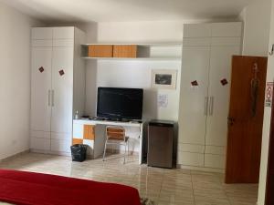 Habitación con TV y escritorio con ordenador. en Sossego e Tranquilidade en Teresina