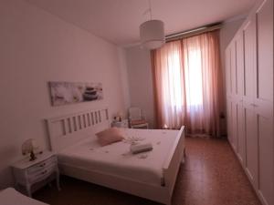 une chambre avec un lit blanc et une fenêtre dans l'établissement Casavacanze Liberty, à La Spezia
