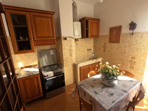 une cuisine avec une table et une cuisinière four supérieur dans l'établissement Casavacanze Liberty, à La Spezia 17 autres photos