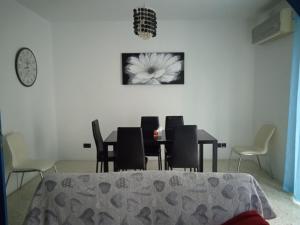 a dining room with a table and chairs and a clock at University Area Msida in Msida