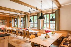 a dining room with tables and chairs and windows at Hotelgasthof Schmucker in Mossautal