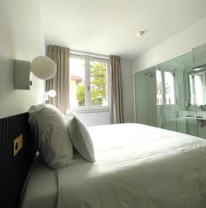 a hotel room with two beds and a window at Le Gamaritz in Biarritz