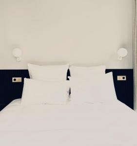 a white bed with a white comforter and pillows at Le Gamaritz in Biarritz