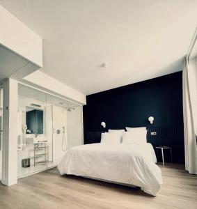 1 dormitorio con 1 cama blanca grande y pared azul en Le Gamaritz en Biarritz