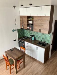 uma cozinha com uma mesa, um lavatório e um fogão em Babi Home em Batumi