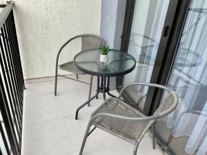 d'une table en verre et de deux chaises sur un balcon. dans l'établissement Babi Home, à Batoumi