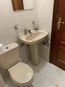 ein Badezimmer mit einer weißen Toilette und einem Waschbecken in der Unterkunft Falda do Pedroso in Santiago de Compostela + 10 Fotos