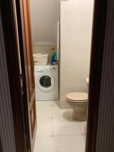 ein Badezimmer mit Waschmaschine und Toilette in der Unterkunft Falda do Pedroso in Santiago de Compostela