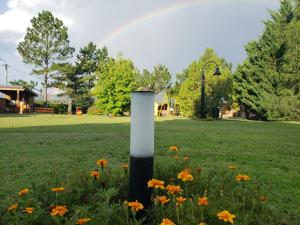 a white pole in the middle of a field with flowers at Complejo Tierra Mia in Panaholma