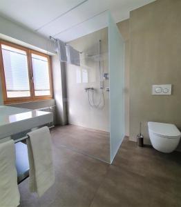 a large bathroom with a shower and a toilet at Hotel-Restaurant Grina in Simplon Dorf