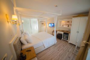 a bedroom with a white bed and a desk at Biga Palas Hotel in Biga