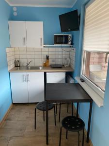 uma pequena cozinha com uma mesa e duas cadeiras em Dom Gościnny Marzena em Międzyzdroje