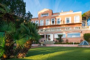 une grande maison avec une pelouse devant elle dans l'établissement B&B Le Logis Du Mas, à Sète