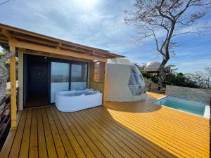 a large deck with a tub on a house at Kintiri Glamping in Nicoya