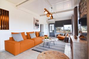 ein Wohnzimmer mit einem orangenen Sofa und einem Tisch in der Unterkunft Nino's Country House in Provatas