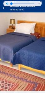 a bedroom with a bed with a blue comforter at Residence Tozeur Almadina in Tozeur