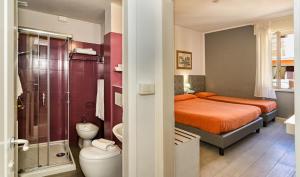 mała łazienka z łóżkiem i prysznicem w obiekcie City Hotel w Viareggio +37 zdjęć
