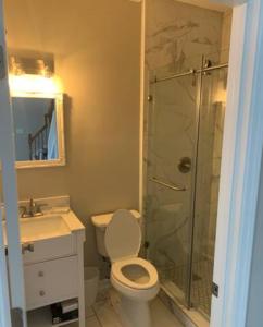 La salle de bains est pourvue de toilettes et d'une douche en verre. dans l'établissement Atlanta Unit 1 Room 3 - Private Bedroom with Private Bathroom, à Atlanta
