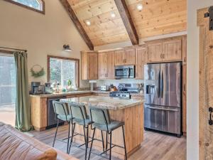 a kitchen with wooden cabinets and a large island with bar stools at Luxury Retreat Custom Mi-Wuk Village Cabin! in Mi-Wuk Village