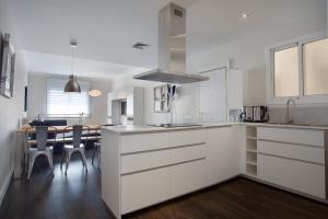 cocina con armarios blancos y mesa de comedor en Consell de Cent Apartment en Barcelona