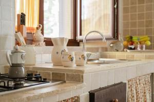 a kitchen counter with cups and a sink at Trulli D'autore in Martina Franca +56 photos