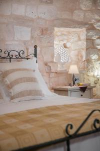 a bedroom with a bed and a stone wall at Trulli D'autore in Martina Franca