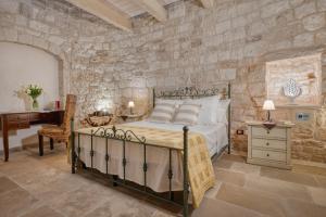 マルティナ・フランカにあるTrulli D'autoreの石壁のベッドルーム1室(ベッド1台付)
