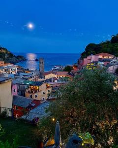 a view of a town at night with the moon at Albergo Degli Amici in Monterosso al Mare