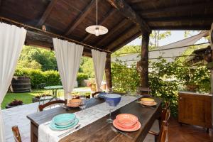an outdoor dining table with plates and wine glasses at Country house with pool and outbuilding Fivizzano by VacaVilla in Terenzano
