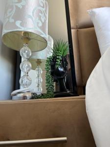 einen Nachttisch mit einer Lampe und einer Pflanze darin in der Unterkunft The Point of View Cabin in Johannesburg