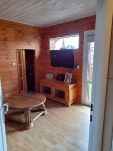 a living room with a table and a tv in a log cabin at Pienińska Hawira in Kluszkowce
