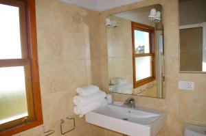 ein Badezimmer mit Waschbecken, Spiegel und Handtüchern in der Unterkunft Casa Lucia in Puntagorda