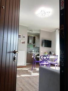 - un salon avec des chaises violettes et une table dans l'établissement Dream lake PANORAMA, garage in the center of Varenna, à Varenna
