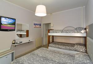 mały pokój z 2 łóżkami piętrowymi i telewizorem w obiekcie City Hotel w Viareggio