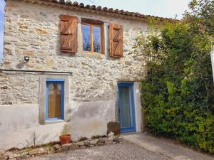 a stone house with blue doors and windows at La maisonnette avec SPA, PISCINE et CLIMATISATION in Sainte-Vallière