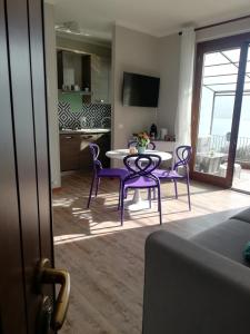 a kitchen and dining room with a table and purple chairs at Dream lake PANORAMA, garage in the center of Varenna in Varenna