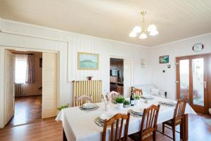 uma sala de jantar com mesa e cadeiras em Vadkacsa apartmanház medencével em Zamárdi