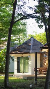 a small white house with a bench in a yard at Avare House Krabi in Ao Nam Mao