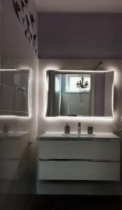 Appartamento Piccola Perla في كولونيو مونزيس: حمام مع حوض ومرآة